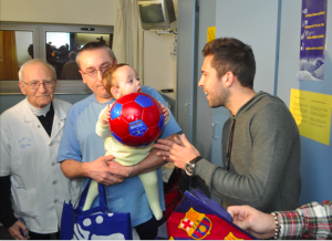Jordi Alba fa entrega d'una pilota a un nadó