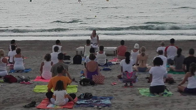 Foto d'arxiu d'un grup de persones practicant ioga a la platja