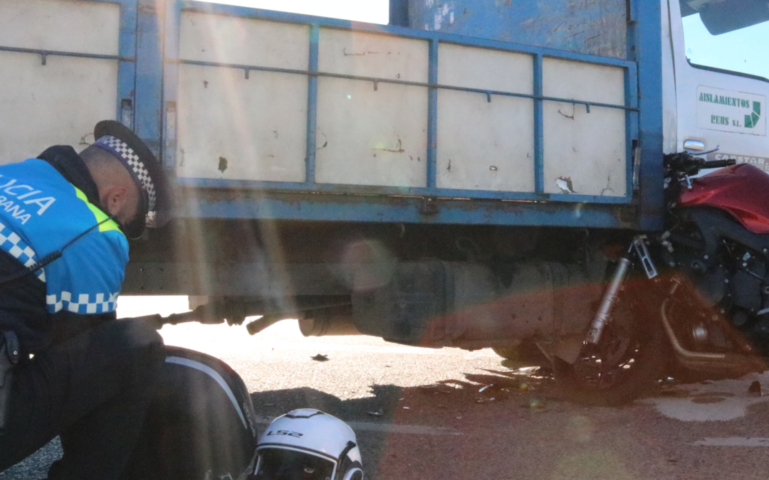 Imatge d'un agent policial observant la moto sinistrada en un accident al terme de Reus, a la carretera TV-7211, en direcció a Constantí, en el qual un motorista ha mort en xocar amb un camió.