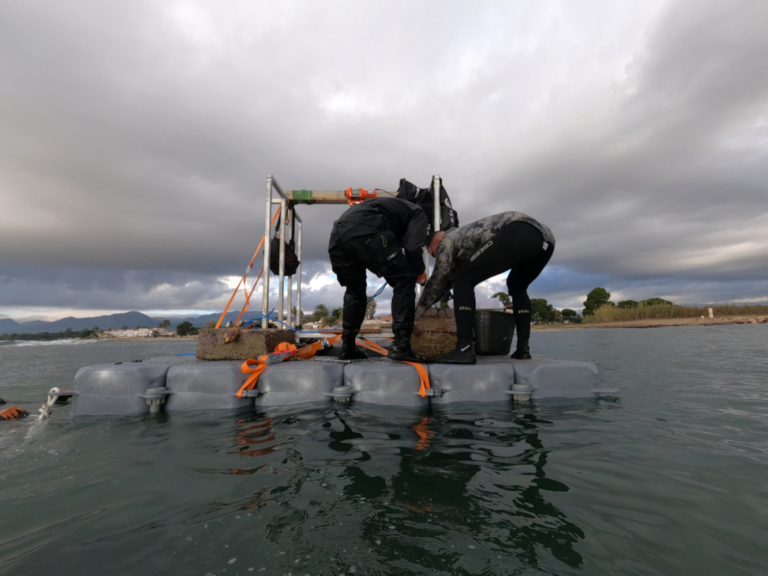 Dos submarinistes durant les tasques d'extracció de residus i blocs de formigó del fons marí. Foto: ACN
