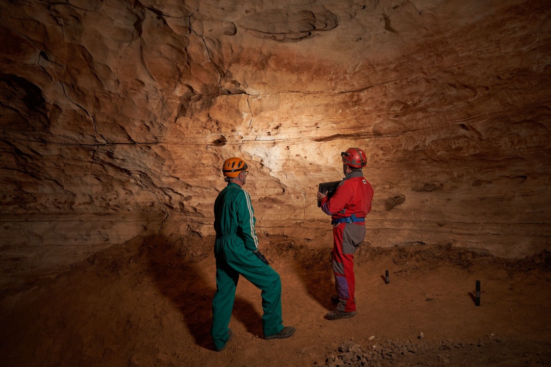 Dos membres del grup d'espeleòlegs a la cova. Foto: Cedida