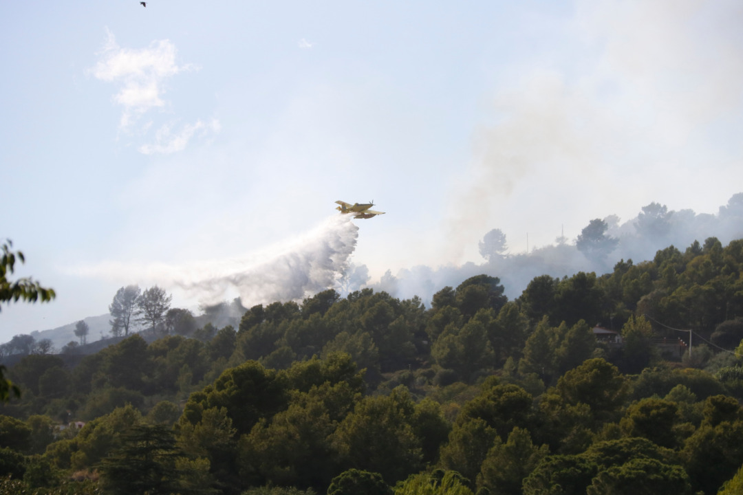 Un dels mitjana aeris de Bombers sobrevolant la zona de l'incendi. Foto: Arnau Martínez