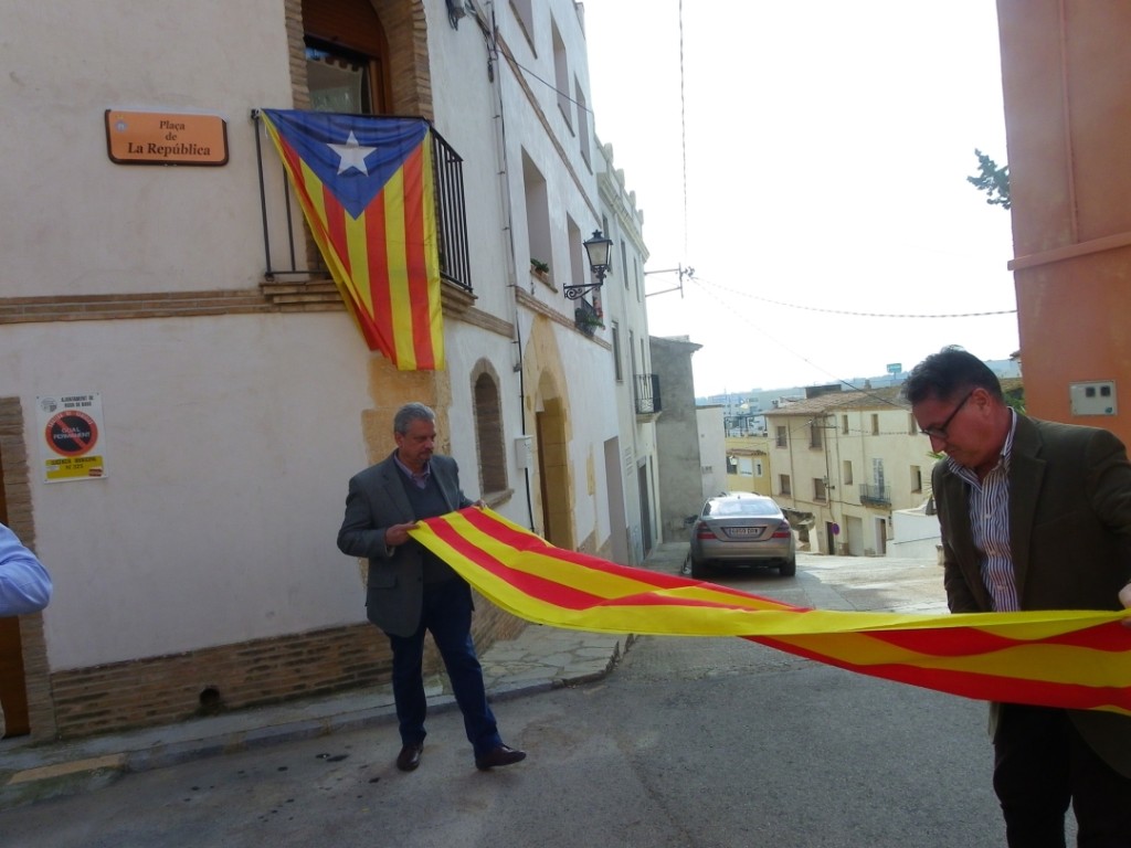 El portaveu del PSC rodenc, Josep Antoni Benedicto, recull la senyera amb l'ajuda de l'alcalde rodenc, Pere Virgili (CiU). Foto: Romà Rofes / Tarragona21.cat