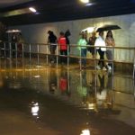 Imatge d'arxiu d'un grup de persones passant pel pont del Serrallo inundat per la pluja. Foto: Ariadna Escoda